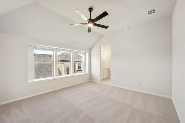 an empty room with large windows and ceiling fan