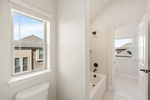 a bathroom with a bathtub shower and toilet