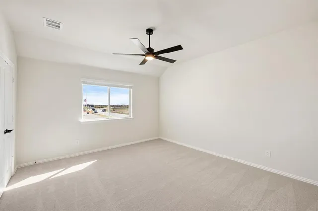 an empty room with a window and a fan