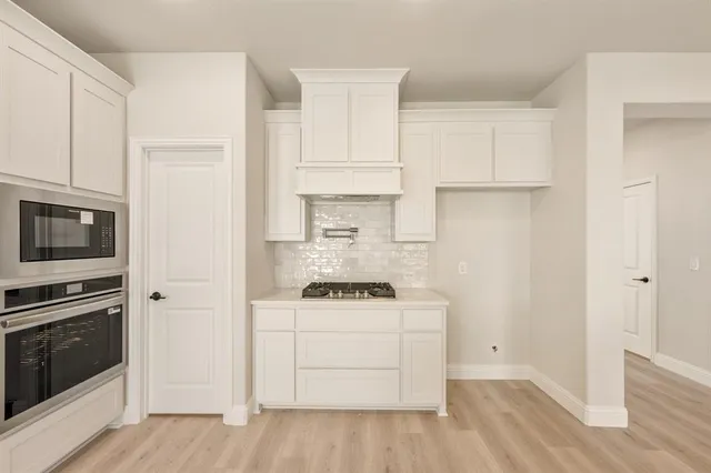 a kitchen with stainless steel appliances white cabinets and a sink