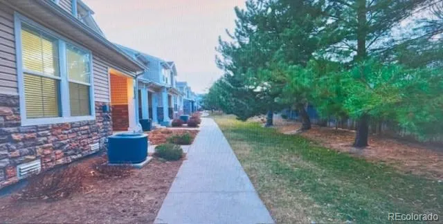 a view of a backyard with potted plants and large trees