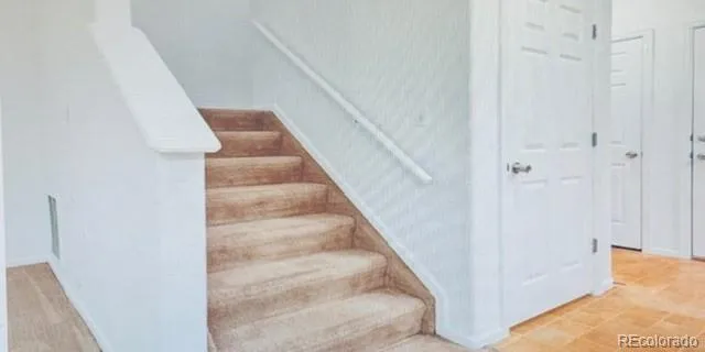 a view of staircase with white walls and door