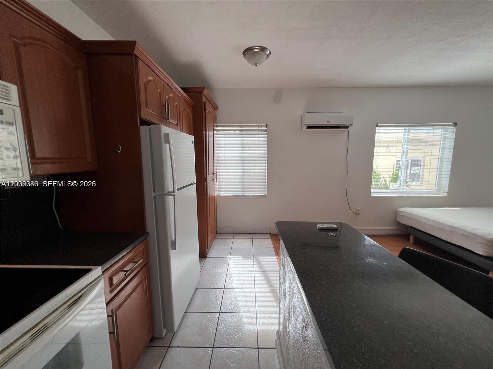 7920 Harding Avenue, Unit 9 Miami Beach, FL 33141 - Photo 4 of 13 a kitchen with a refrigerator and a stove