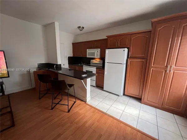 a view of a workspace with furniture and a refrigerator