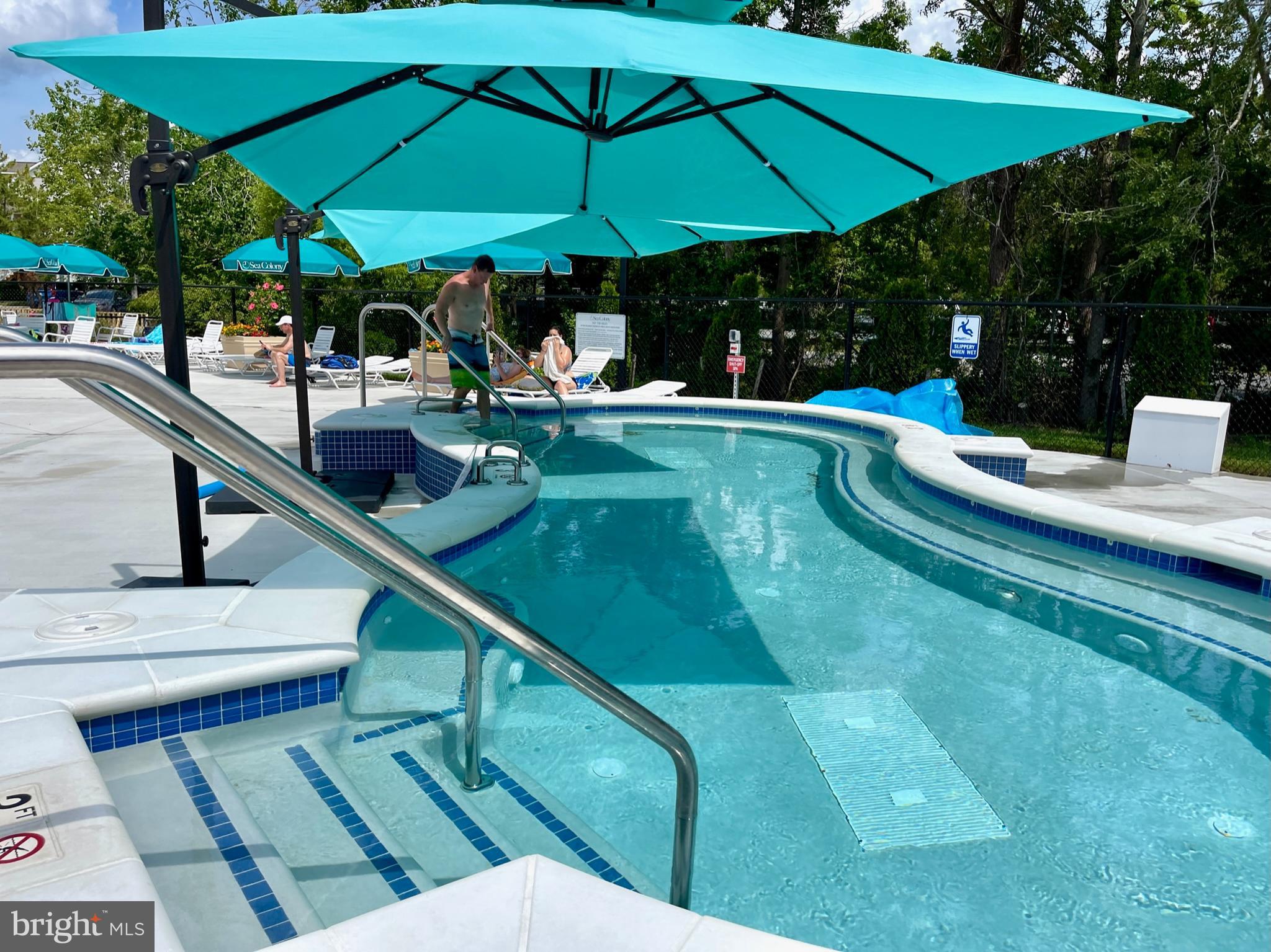 311 Georgetown House Bethany Beach, DE 19930 - Photo 36 of 48 a view of a swimming pool with chairs in patio