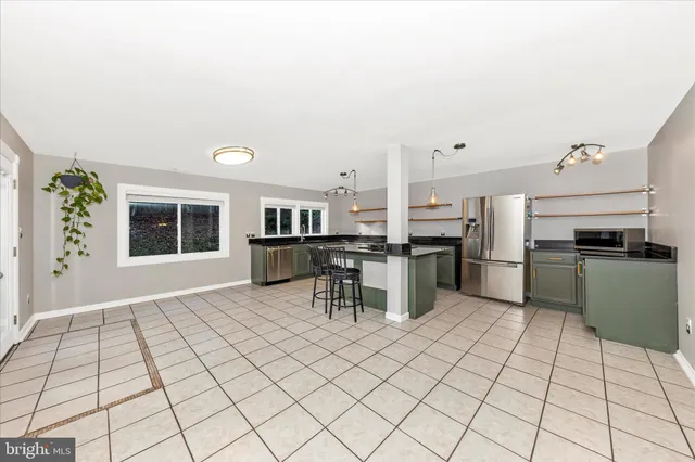 a kitchen with granite countertop a sink cabinets and stainless steel appliances