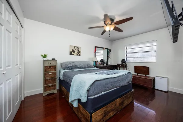 a bedroom with a bed a flat screen tv and dresser