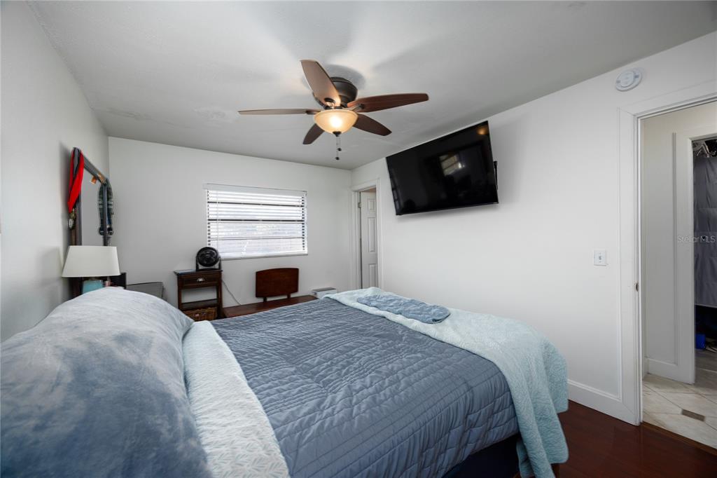 8031 Southwest 13th Road Gainesville, FL 32607 - Photo 19 of 40 a bedroom with a bed a flat screen tv and dresser