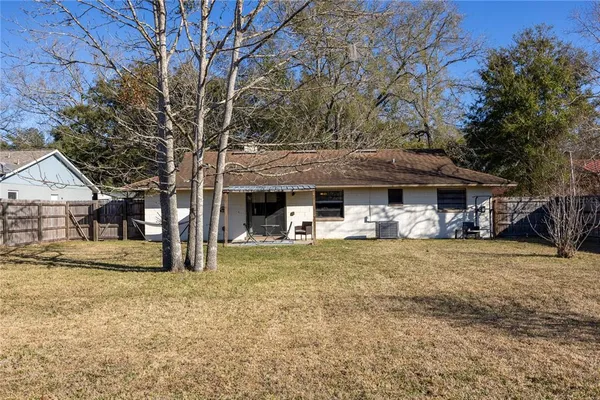 a view of a house with backyard and trees