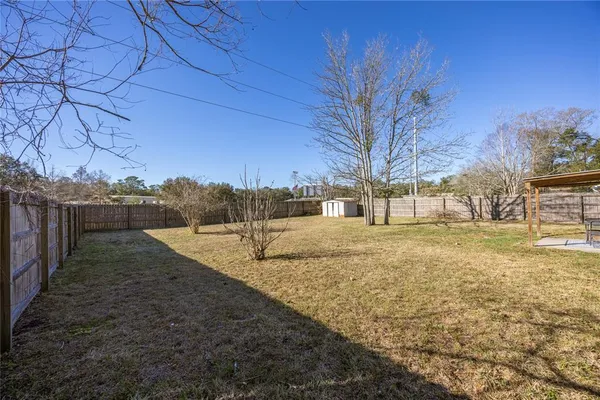 a view of backyard with wooden fence