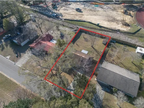an aerial view of a house a yard wooden table and chairs