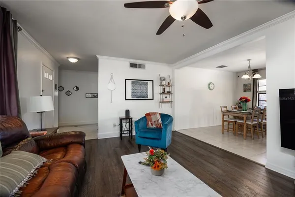 a kitchen with stainless steel appliances kitchen island granite countertop a dining table chairs and a refrigerator