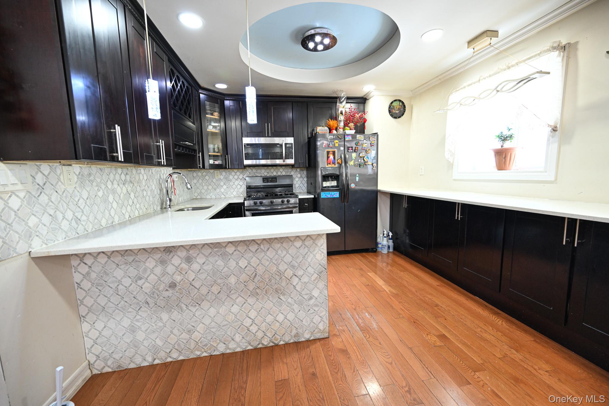 176-25 133rd Road Queens, NY 11434 - Photo 10 of 15 a kitchen with stainless steel appliances granite countertop a sink a stove and a wooden cabinets