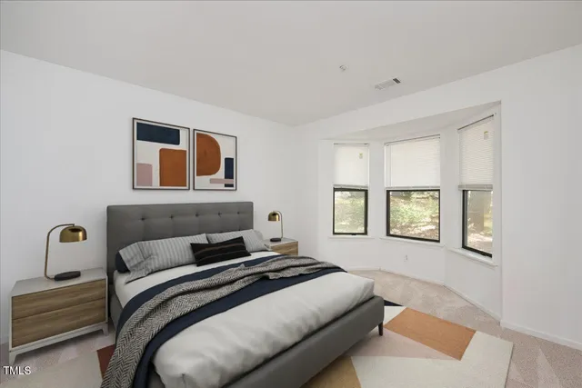 a bedroom with a bed and a painting on the wall