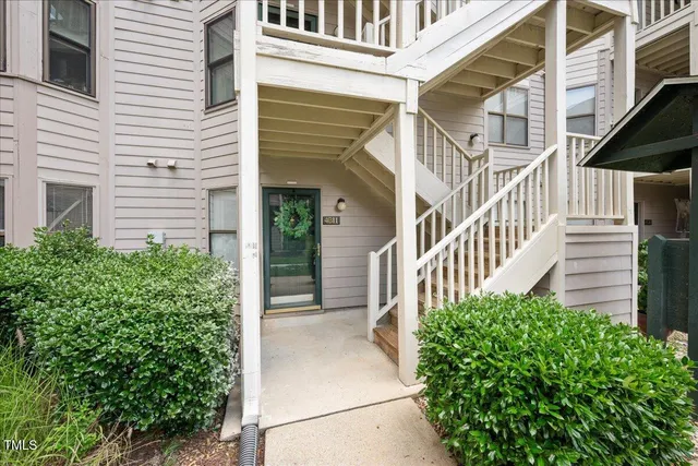 a view of a house with a small yard and flower plants