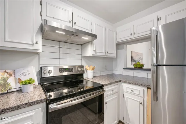 a kitchen with stainless steel appliances granite countertop a refrigerator and a stove