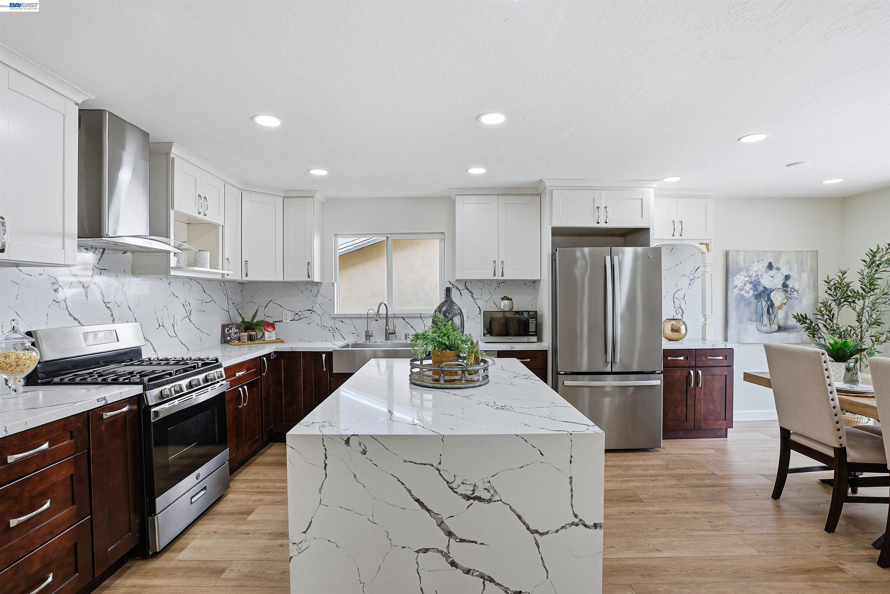 6738 Rancho Court Pleasanton, CA 94588 - Photo 13 of 33 a kitchen with stainless steel appliances a stove a refrigerator a sink a dining table and chairs