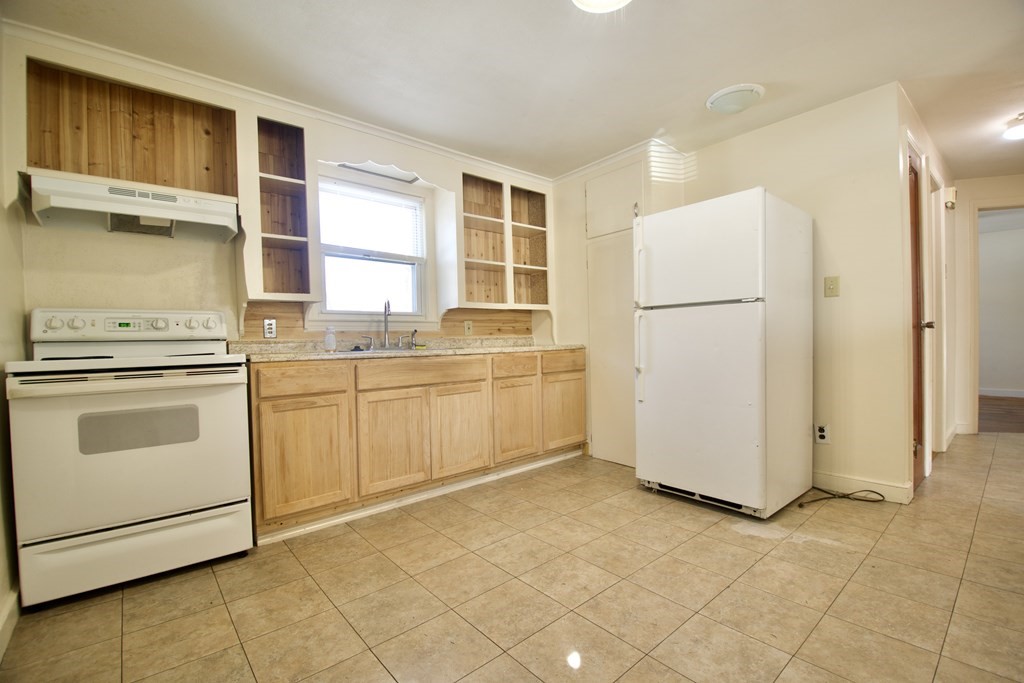 1046 Liberty Street Springfield, MA 01104 - Photo 3 of 19 a kitchen with a stove a sink and a refrigerator
