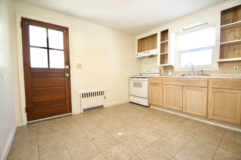 1046 Liberty Street Springfield, MA 01104 - Photo 5 of 19 a view of a kitchen with white cabinets and white appliances