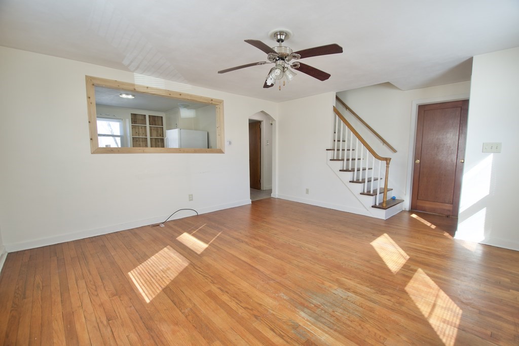 1046 Liberty Street Springfield, MA 01104 - Photo 6 of 19 a view of an empty room with wooden floor and a ceiling fan