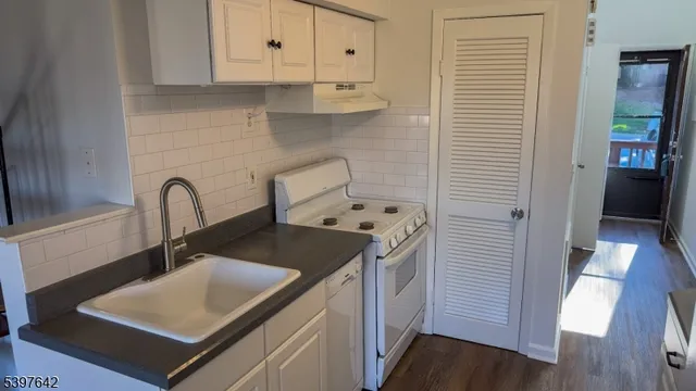 a close view of a sink a stove and cabinets in a kitchen