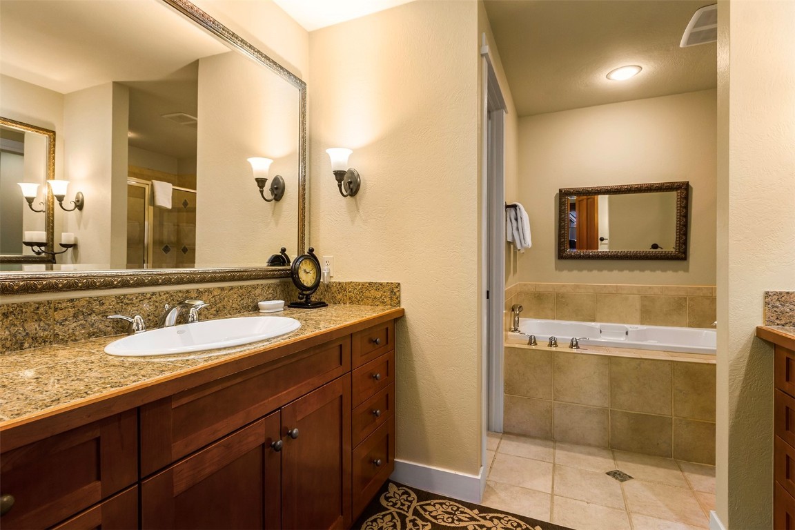 55 Westridge Road, Unit 55 Breckenridge, CO 80424 - Photo 25 of 42 a bathroom with a granite countertop sink a mirror and a shower
