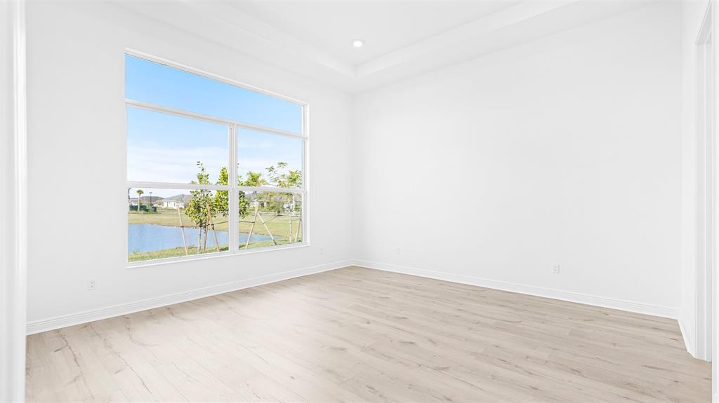 5237 Rivo Alto Circle Westlake, FL 33470 - Photo 18 of 63 an empty room with wooden floor and windows