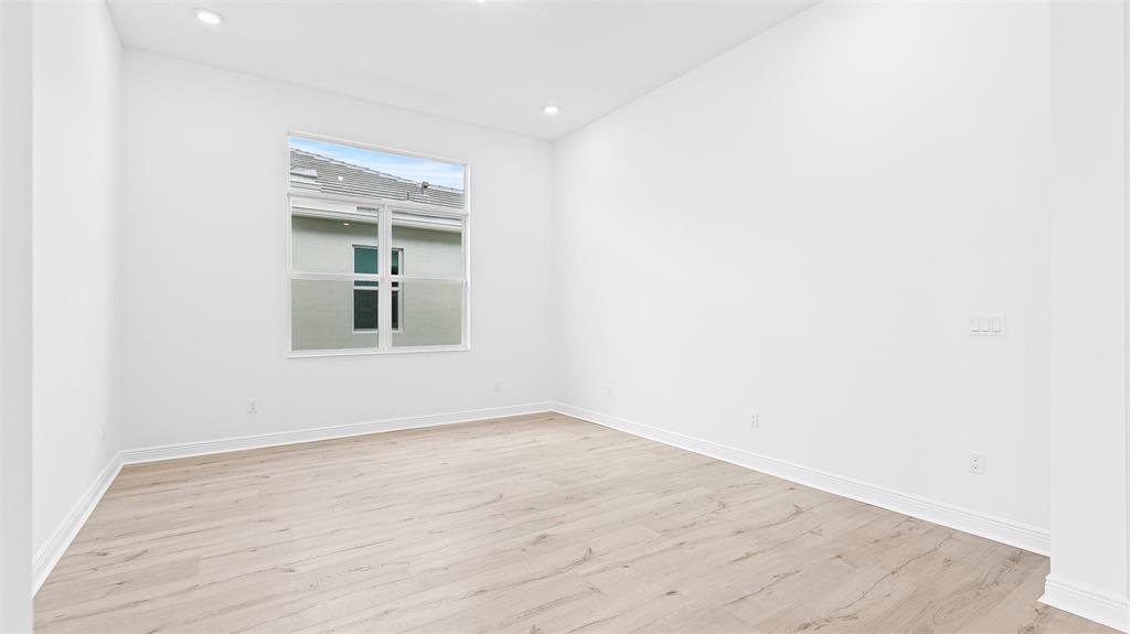 5237 Rivo Alto Circle Westlake, FL 33470 - Photo 28 of 63 a view of an empty room with wooden floor and a window