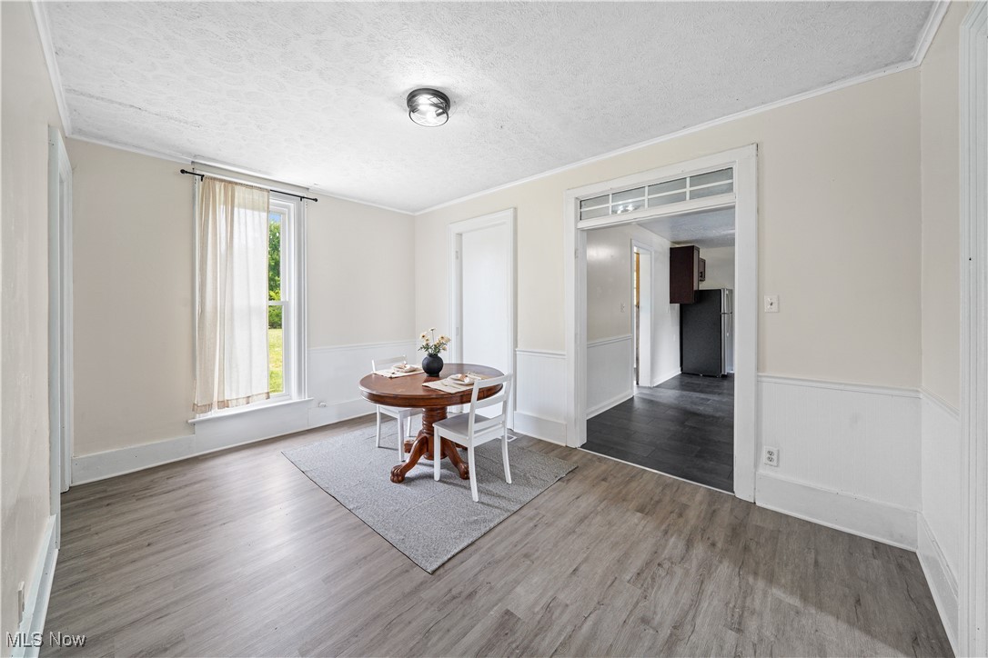 6118 Institute Road Rome, OH 44085 - Photo 6 of 27 Dining space with wood finished floors, crown molding, and a textured ceiling