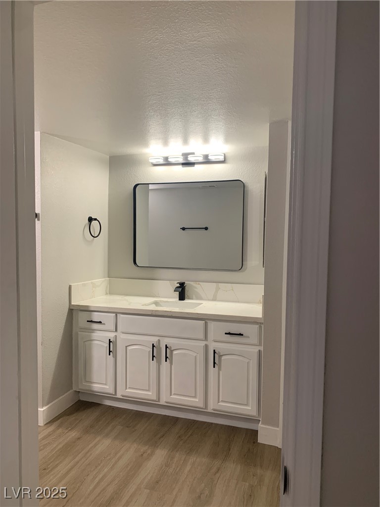8101 West Flamingo Road, Unit 1102 Las Vegas, NV 89147 - Photo 49 of 54 Bathroom featuring wood finished floors and vanity