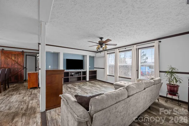 a kitchen with stainless steel appliances granite countertop a refrigerator a sink a stove and a wooden floors