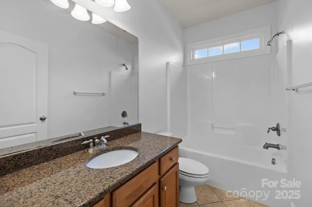 a bathroom with a granite countertop sink toilet a large mirror a bathtub and shower