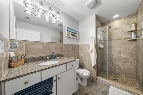 a bathroom with a granite countertop sink toilet and shower