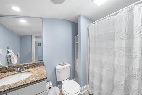 a bathroom with a granite countertop sink toilet and shower