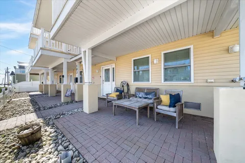 a living room with couches and kitchen view with wooden floor