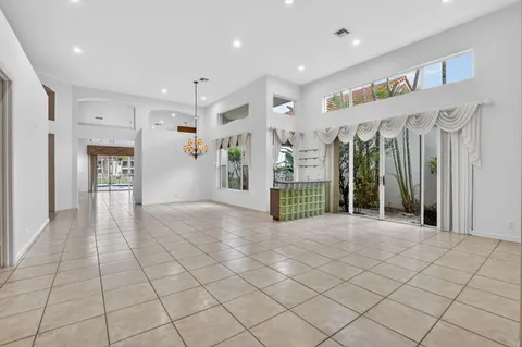 a view of empty room with wooden floor and chandelier