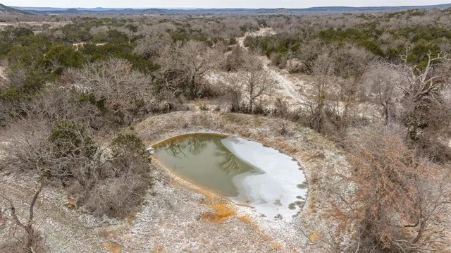 a view of a field with trees in the background