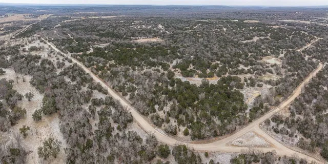an aerial view of a house with a mountain