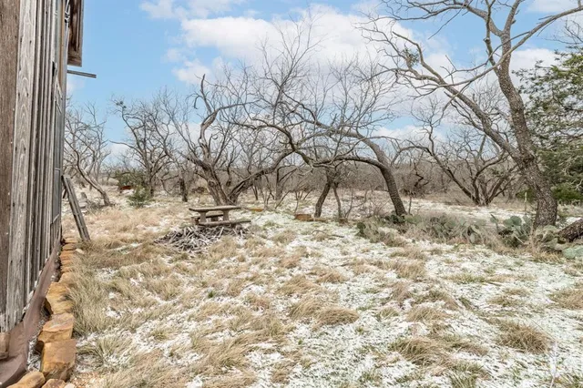 a backyard of a house with barbeque oven and wooden fence