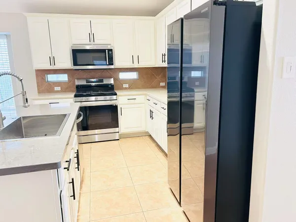 a kitchen with stainless steel appliances a stove a sink and a refrigerator