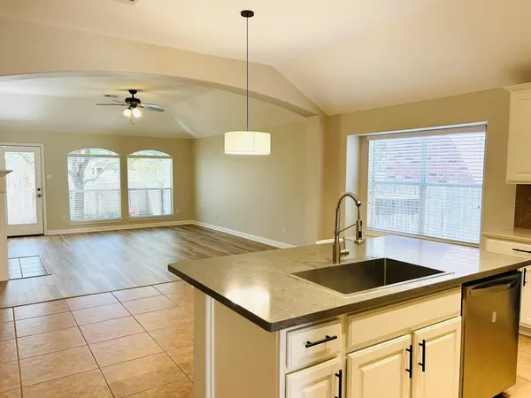a kitchen with a sink a stove and chandelier