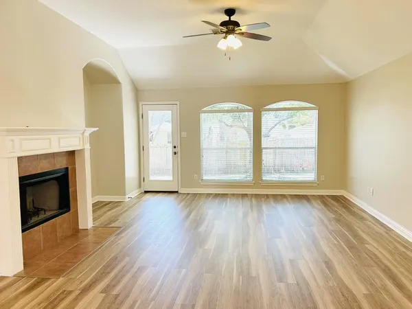 a view of empty room with wooden floor and fireplace