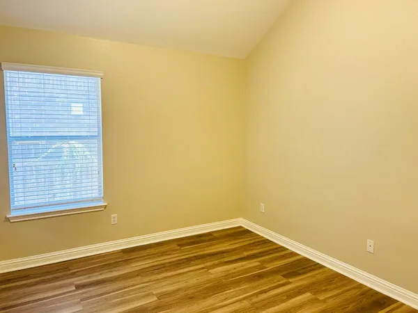 a view of a room with wooden floor and a window