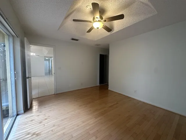 a view of an empty room and a ceiling fan