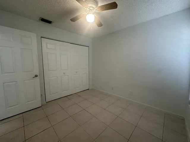 an empty room with a ceiling fan and a window