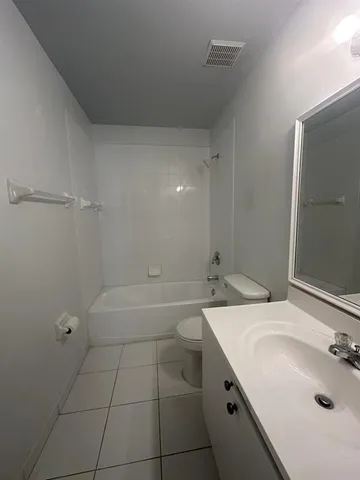 a bathroom with a sink a tub and a mirror