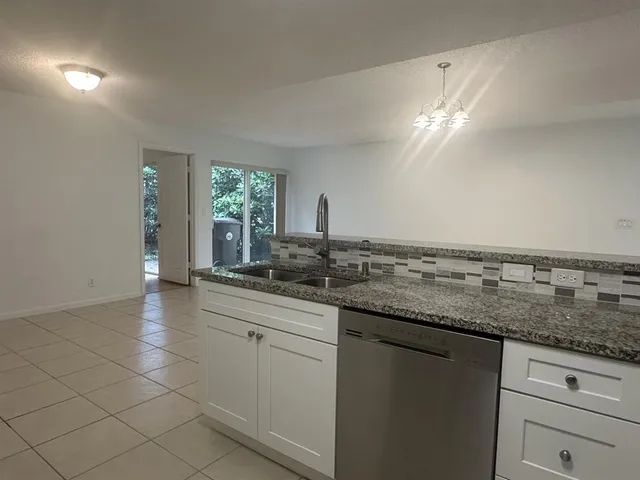 a bathroom with a granite countertop sink and a large mirror
