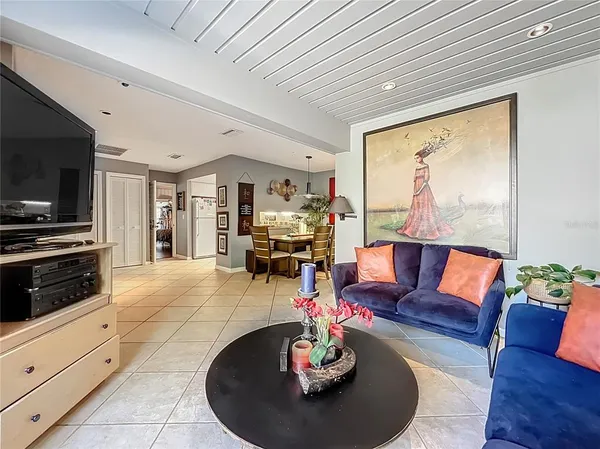 a living room with furniture a flat screen tv and kitchen view