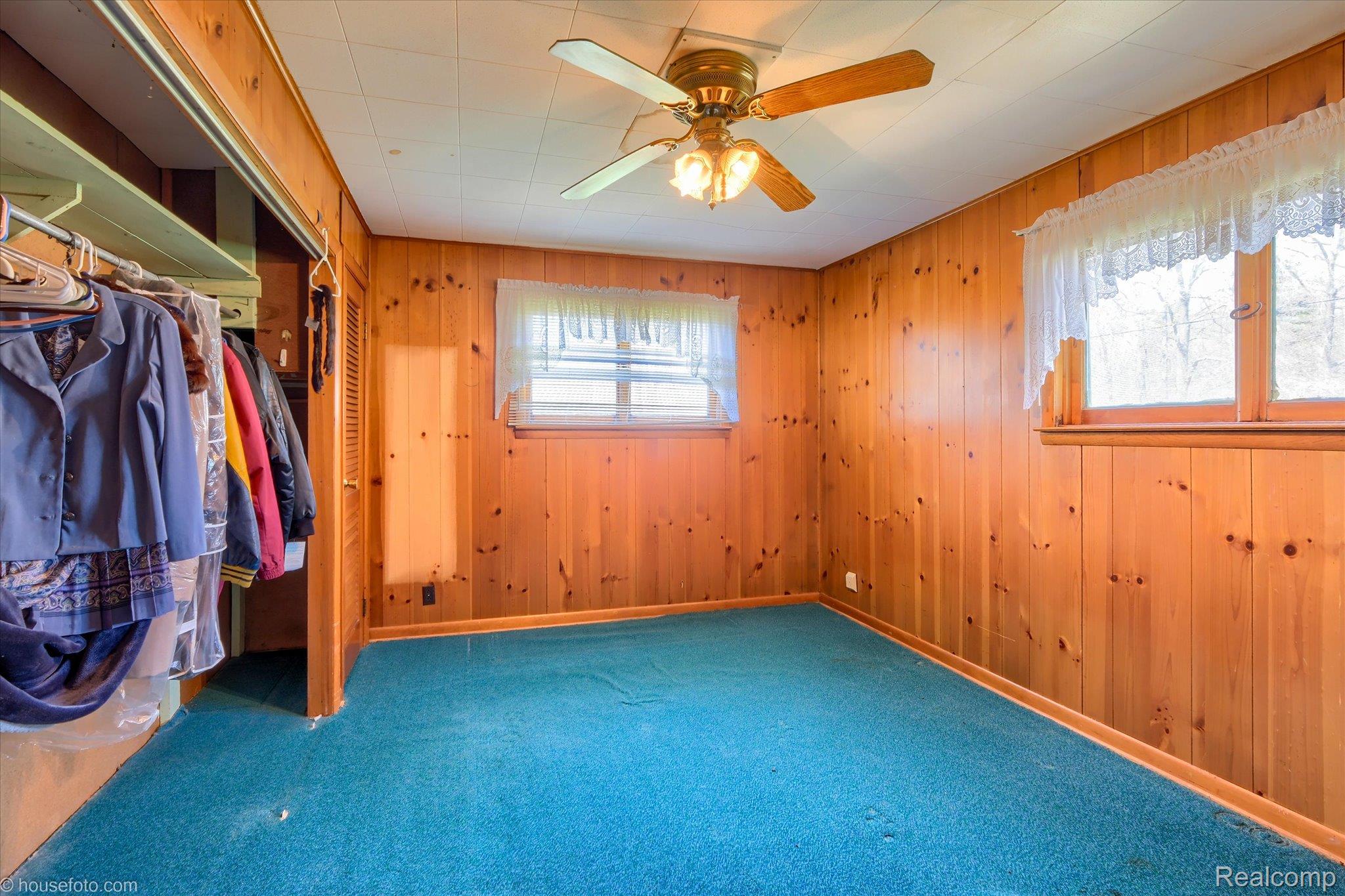 1325 Barnes Lake Road North Branch, MI 48461 - Photo 20 of 42 Unfurnished bedroom with a closet, ceiling fan, wood walls, and carpet flooring