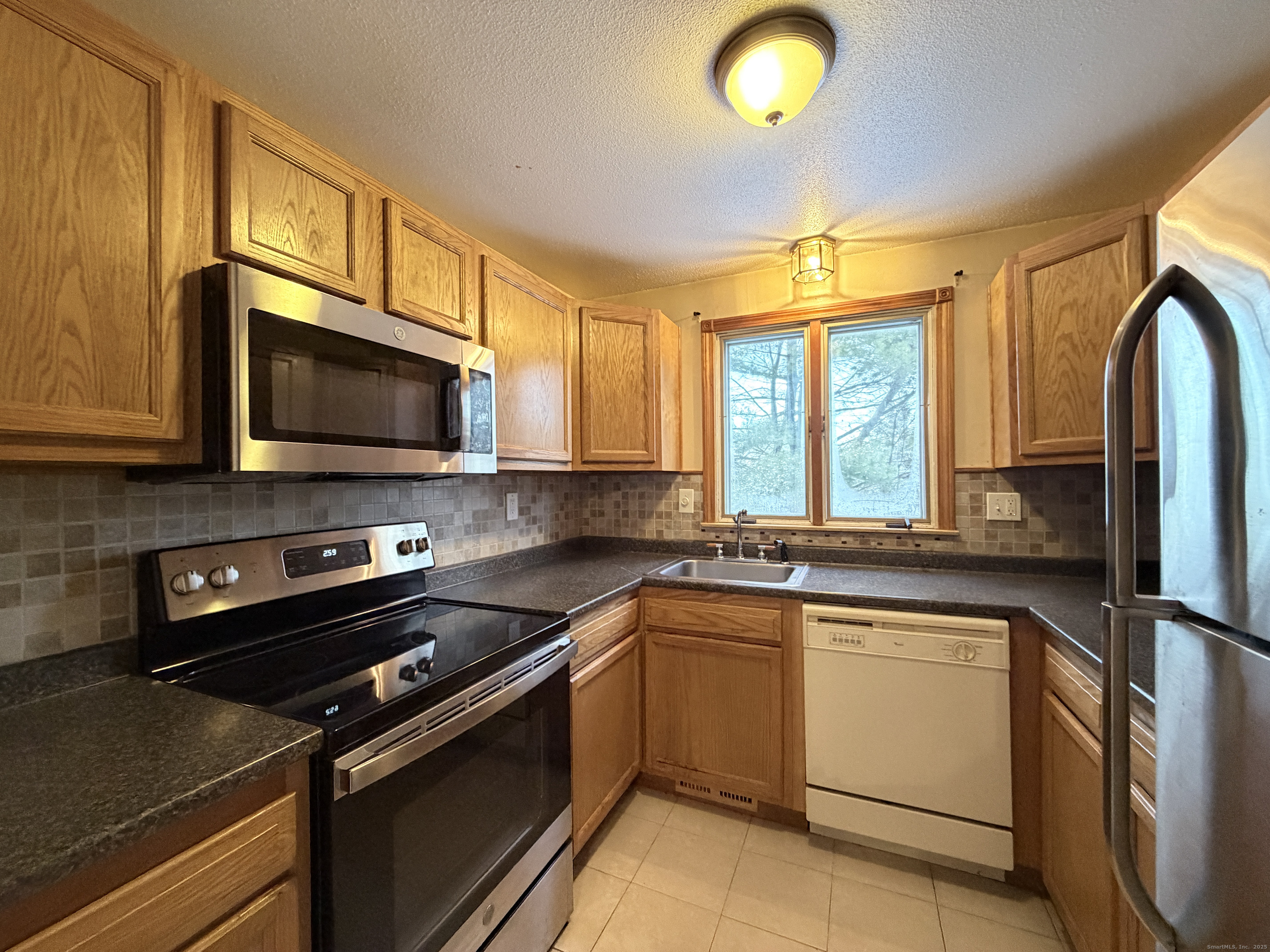 105 Spring Lane, Unit 105 Suffield, CT 06078 - Photo 2 of 16 a kitchen with a sink stove and microwave